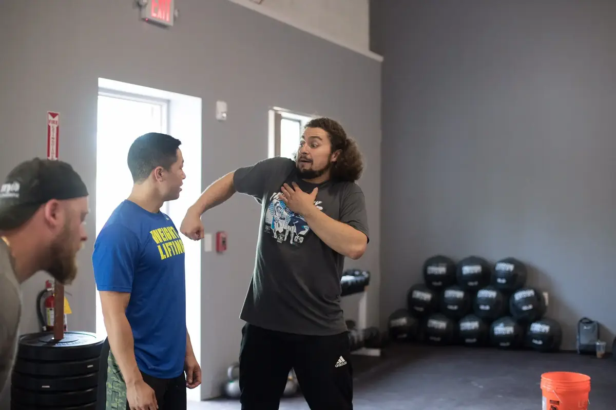 Norik Vardanian demonstrating proper arm and shoulder position to an athlete during a coaching session